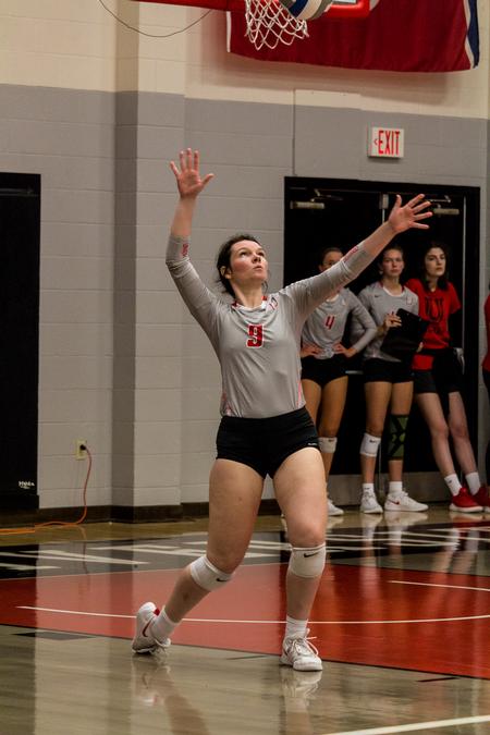 Audrey Cagle, junior, serves the ball in a volleyball game against Belmont Abbey College. - Photo by Nikki Grim