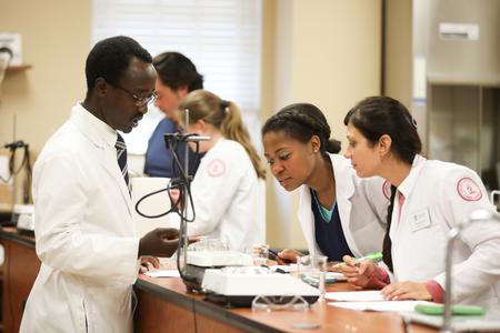 Richard Addo, professor of pharmaceutical sciences, works with students during a lab. - Photo by Kristi McMurry Woody