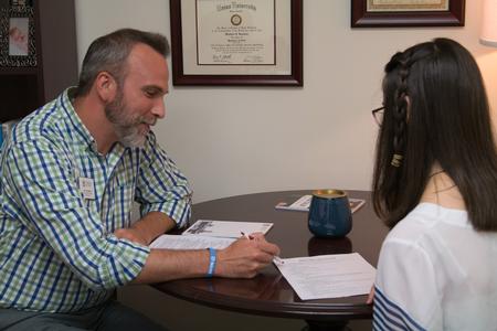 Matt Bowman, employer relations and recruitment manager, helps a student with her resume during Walk-in Monday in the Vocatio Center.  - Photo by Lynn Tucker