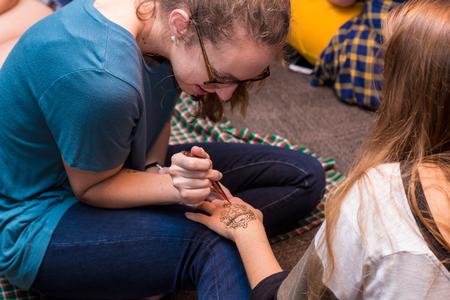 Female students receive henna tattoos at the Henna Night event as part of Global Focus Month. - Photo by Nikki Grim
