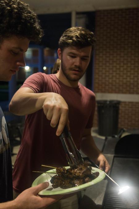 Students enjoy some grilled skewers during the Global Focus Month event Thai & Fry Grill Night. - Photo by Riley Boggs