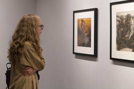 Madison Borden, pre-professional art therapy major, looks at the work of illustrator Ron Mazellan in the Union Art Gallery. - Photo by Lynn Tucker