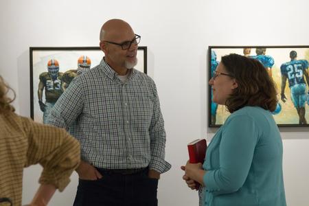 Illustrator Ron Mazellan talks with Melinda Posey, associate professor of art, during Mazellan's gallery opening at the Union Art Gallery.  - Photo by Lynn Tucker