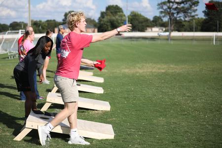 Layton Estes, accounting major, plays cornhole during the Community Appreciation event hosted by Undergraduate Admissions.  - Photo by Kristi McMurry Woody