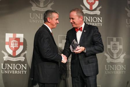 William Trevathan ('00) receives his Distinguished Achievement Award in Athletics from Dub Oliver, president of the university, during the Meritorious Service Awards Banque.  - Photo by Kristi McMurry Woody