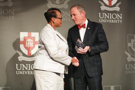 Florence Jones ('12) receives her Distinguished Achievement Award in Healthcare from Dub Oliver, president of the university, during the Meritorious Service Awards Banquet.  - Photo by Kristi McMurry Woody