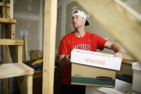 Members of the baseball team help move boxes of files at The Star Center during Campus & Community Day.  - Photo by Kristi McMurry Woody