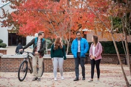 Students chat with Santhosh Abraham (second from right), associate professor of accounting, on a fall day. - Photo by Kristi McMurry Woody