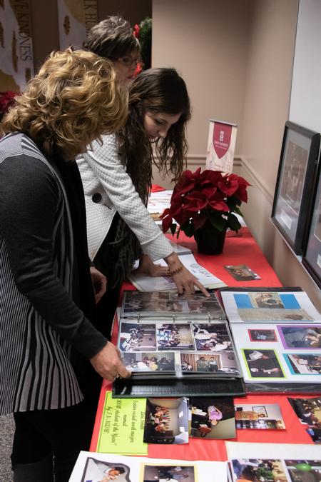 Guests of a reception celebrating the 20th anniversary of the School of Social Work look through scrapbooks. - Photo by Joey Echeverria