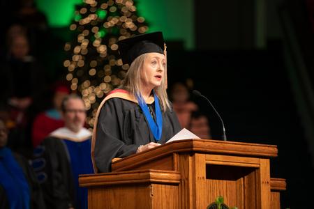 Brooke Emery, assistant professor of marketing, reads from scripture at the beginning of Fall Commencement. - Photo by Kristi McMurry Woody