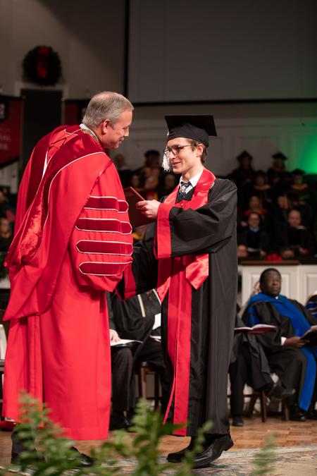 Joshua Welsch, English graduate, receives his diploma during Fall Commencement. - Photo by Kristi McMurry Woody