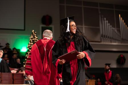 Ceciley Blanchard, studio art graduate, looks out at her friends and family after receiving her diploma during Fall Graduation. - Photo by Kristi McMurry Woody