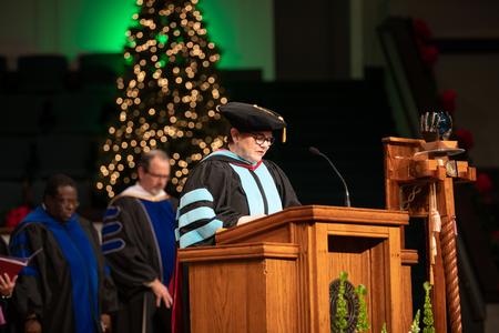 Carla Cushman, associate professor of educational leadership, opens the second Fall Commencement service with prayer. - Photo by Kristi McMurry Woody