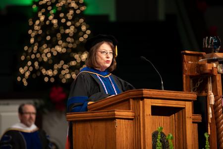 Connie Cupples, professor of nursing, reads scripture during the second Fall Commencement service.  - Photo by Kristi McMurry Woody