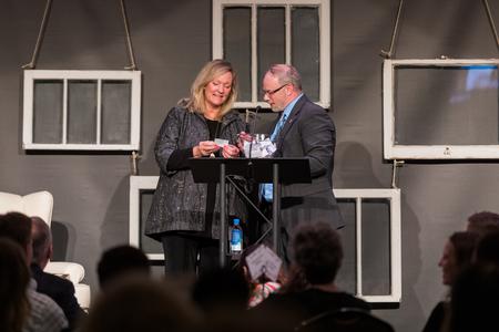 Christian novelist Karen Kingsbury draws a winner for a scholarship during the Auxiliary Banquet. - Photo by Kristi McMurry Woody
