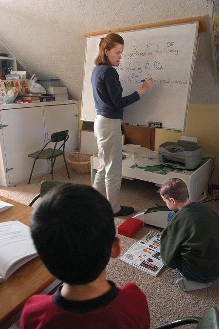 <i>Salazar Family C&C Profile</i> - Keri leads the twins in an English lesson as oldest son Caleb studies on his own. - Photo by Kristen Nicole Sayres