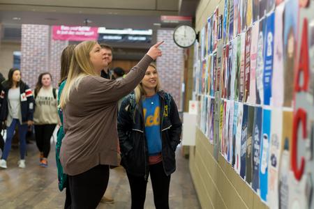 Students look at posters for sale in the SUB Hallway during the graphic design students' annual AIGA Poster Sale. - Photo by Nikki Grim