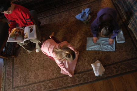 <i>Salazar Family C&C Profile</i> - The girls help fold laundry as their brother, Isaiah, reads. - Photo by Kristen Nicole Sayres