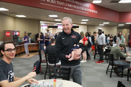 Dub Oliver, president of the university, and his granddaughter chat with students in the Brewer Dining Hall during a celebration of his 5 years at Union. - Photo by Kristi McMurry Woody