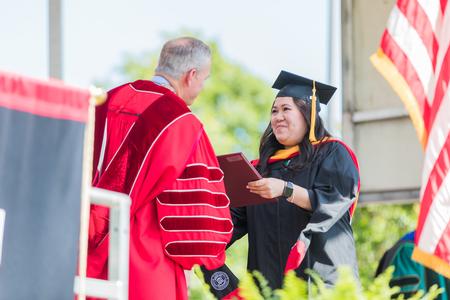 A student receives her diploma during spring commencement. - Photo by Kristi McMurry Woody