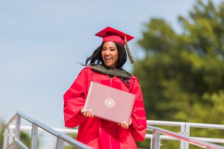 Larina Bourne, doctor of pharmacy graduate, walks off the stage with her diploma at spring commencement. - Photo by Kristi McMurry Woody