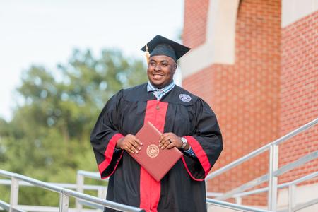 Justice Walker, mathematics graduate, walks off the stage after receiving his diploma during spring commencement. - Photo by Kristi McMurry Woody