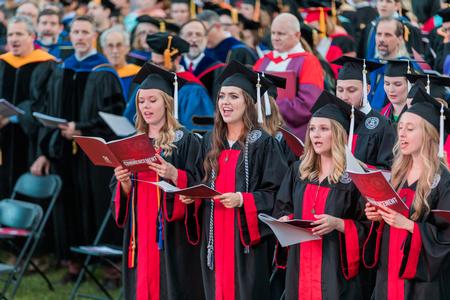 Graduates sing the alma mater at the end of spring commencement. - Photo by Kristi McMurry Woody