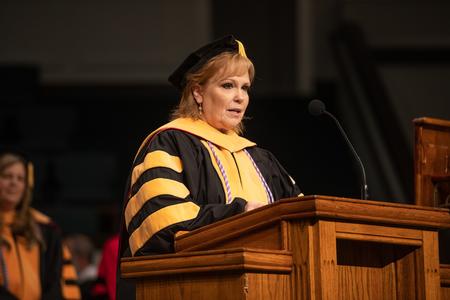 Molly Wright, professor of nurse anesthesia and department chair, reads from the gospel of Matthew during summer graduation. - Photo by Kristi McMurry Woody