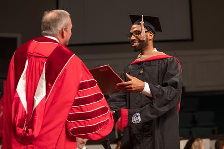Jarren Meredith, master of business administration graduate, receives his diploma at Union University's summer commencement. - Photo by Kristi McMurry Woody