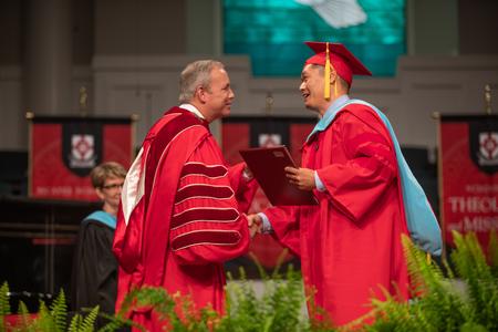 Kevin Ung, doctor of education graduate, receives his diploma during summer graduation. - Photo by Kristi McMurry Woody
