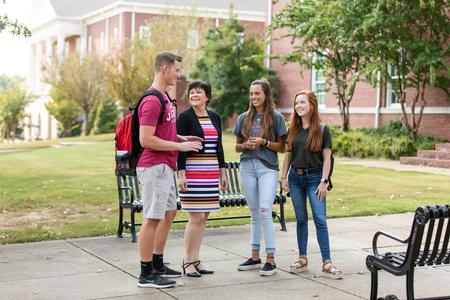 Ashley Blair, acting chair and associate professor of communication arts, talks with students outside Jennings Hall. - Photo by Kristi McMurry Woody