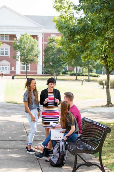 Ashley Blair, acting chair and associate professor of communication arts, talks with students outside Jennings Hall. - Photo by Kristi McMurry Woody