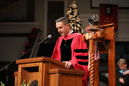 Jason Crawford, faculty member of the year, opens fall graduation with prayer.  - Photo by Kristi McMurry Woody