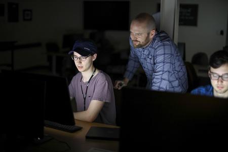 Brian Glas, assistant professor of computer science, works with a student in the computer lab. - Photo by Kristi McMurry Woody