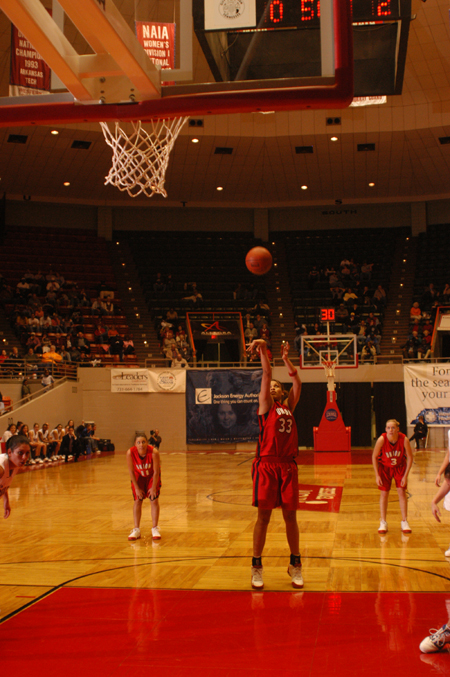 Stephanie Clark (10) attempts a free throw during the opening round game of the 2005 NAIA National Tournament.  Jennifer Henson (left) and Crystal Eason (right) look on from behind. - Photo by Morris Abernathy