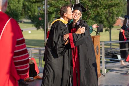 Addie Ruth Carter, Spanish and public relations graduate, hugs her dad, Gary Carter, as she walks across the stage to receive her diploma. - Photo by Kristi McMurry Woody