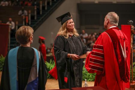 Jennifer Gay, MBA graduate, receives her diploma during summer graduation. - Photo by Kristi McMurry Woody