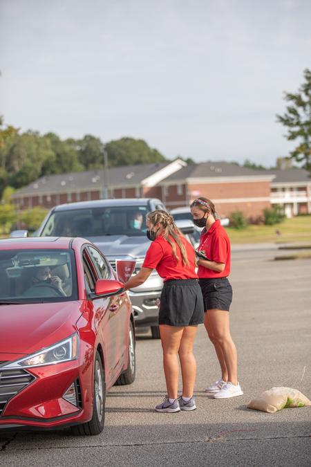 Student residence advisors check in new students inside their vehicles during Move-in Day. - Photo by Kristi McMurry Woody