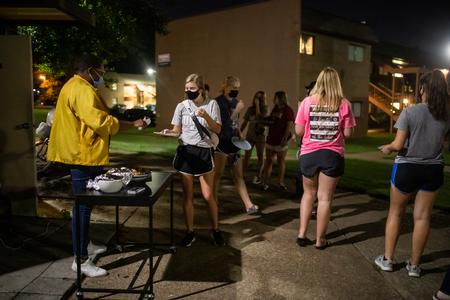 Ashley Akerson, residence director, serves sausage balls during Res Life's Progressive Snacking. - Photo by Kristi McMurry Woody