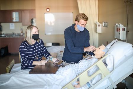 Jennifer Delk, assistant professor of nursing, and Nathanael Dean, senior nursing major, work in one of the simulation labs in Providence Hall. - Photo by Kristi McMurry Woody