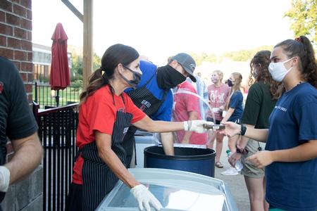 Susie Oliver, first lady of the university, serves ice cream to new students during Welcome Week.  - Photo by Joey Echeverria