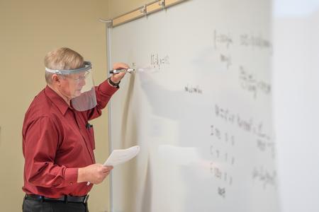 Michael Hayes, professor of chemistry and department chair, writes on the board for his students. - Photo by Kristi McMurry Woody