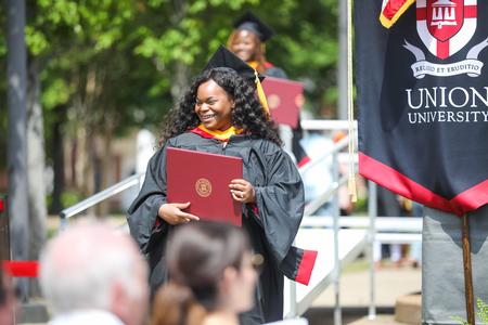 Graduates leave the stage after receiving their diplomas during spring commencement. - Photo by Kristi McMurry Woody