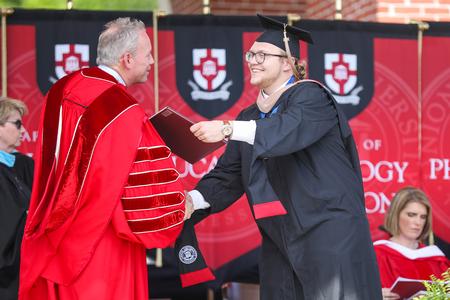 Nathan Heatherly, master of business administration graduate, receives his diploma during spring commencement. - Photo by Kristi McMurry Woody
