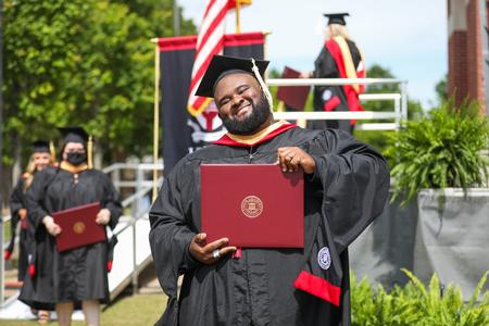 Gregory Perry, master of social work graduate, celebrates receiving his diploma during spring graduation. - Photo by Kristi McMurry Woody