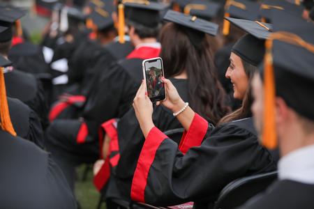 Graduates post to social media to celebrate their accomplishment during spring commencement. - Photo by Kristi McMurry Woody