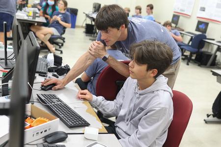 Georg Pingen, professor of engineering, helps a camper with his design during 3D Printing Camp. - Photo by Kristi McMurry Woody