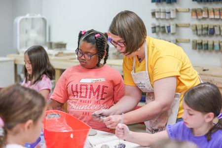 Paige Ward, instructional staff, works with campers during a Ceramics Camp. - Photo by Kristi McMurry Woody