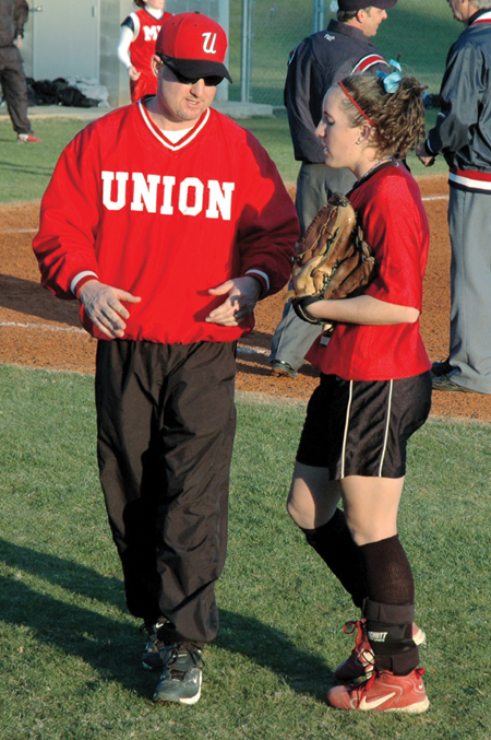 Union head coach Brian Dunn talks with senior left fielder Allison Shein between innings during a Union softball game. - Photo by Amanda Herron