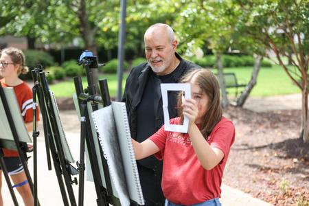 Students in Drawing 1 do a drawing exercise outside during class. - Photo by Kristi McMurry Woody
